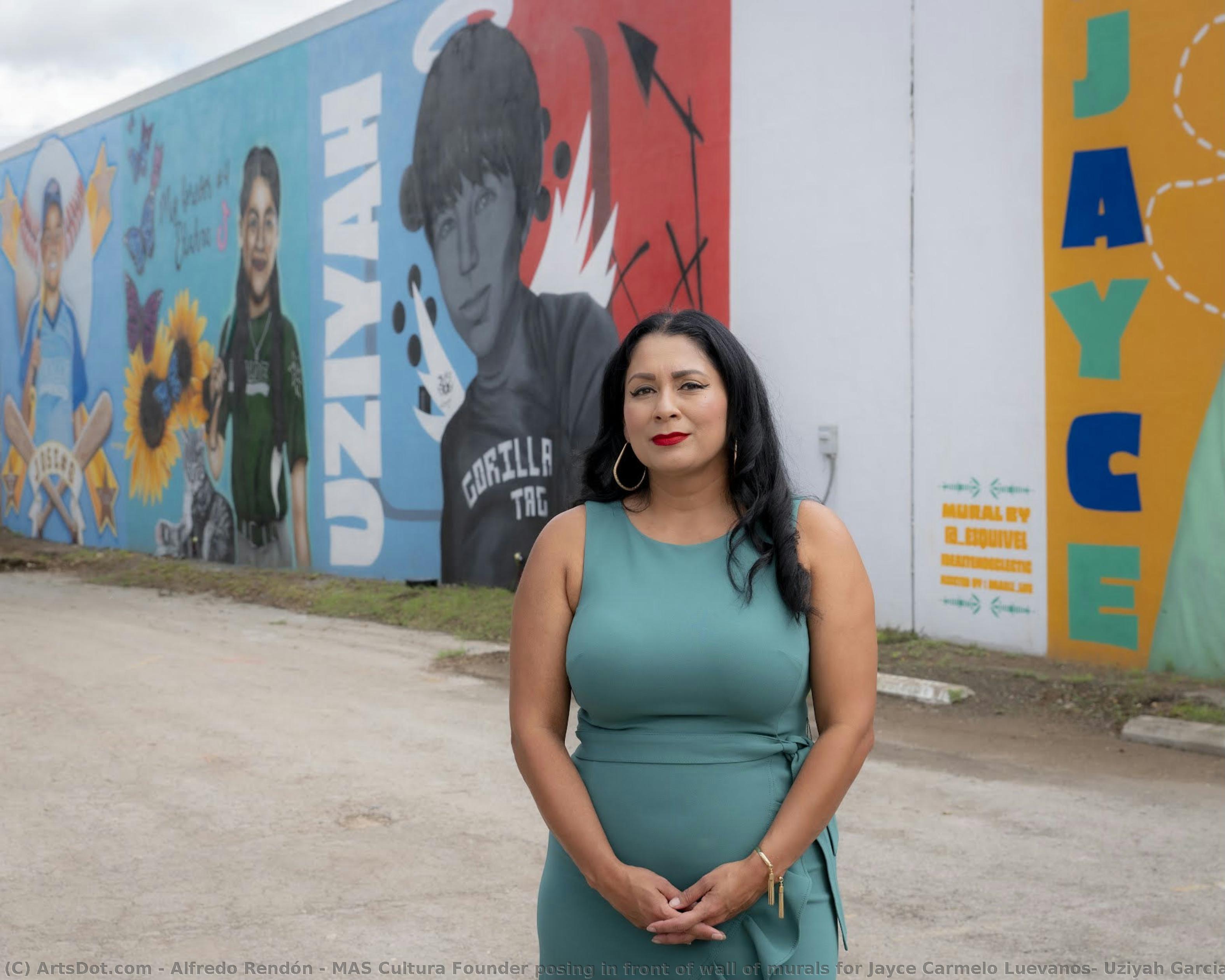 Mas Cultura Founder Posing In Front Of Wall Of Murals For Jayce Carmelo Luevanos, Uziyah Garcia, Eliahna Torres, And Jose Manuel Flores — Alfredo Rendón