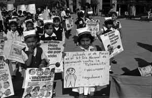 Schoolchildren march through the streets in Mexico carrying banners in favour of immunization
