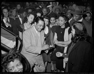 Duke Ellington Signing Autographs In A Crowd, Including Audrey Brannom With Folded Arms Wearing Bracelets, Isadora Marable, And Marverine And Blanche Cathcart — Charles Harris, Documentary Photography