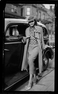 Woman, possibly Barbara Jones, posed next to car on Mulford Street, Homewood