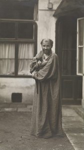 Gustav Klimt, holding a cat in his arm