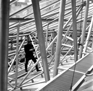 History Faculty, West Road, Cambridge: Reyner Banham With His Camera On The Catwalk Of The Roof-truss System — Peter Reyner Banham